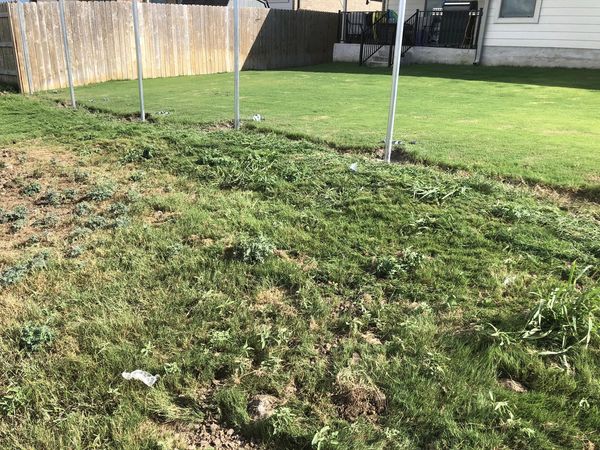 Deconstructed wooden deck with metal poles and fence in the background.