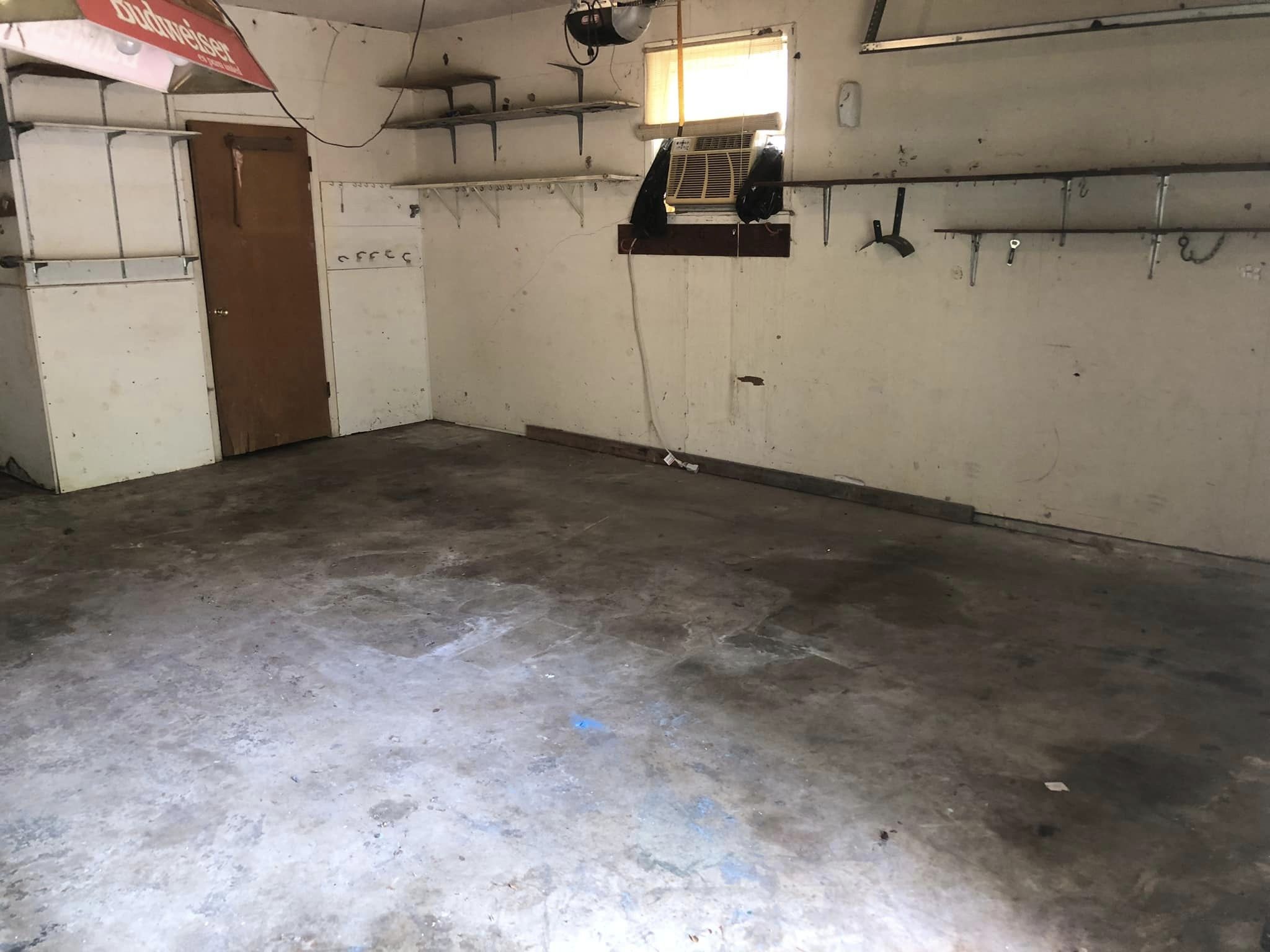 Empty garage interior with concrete floor and shelves.
